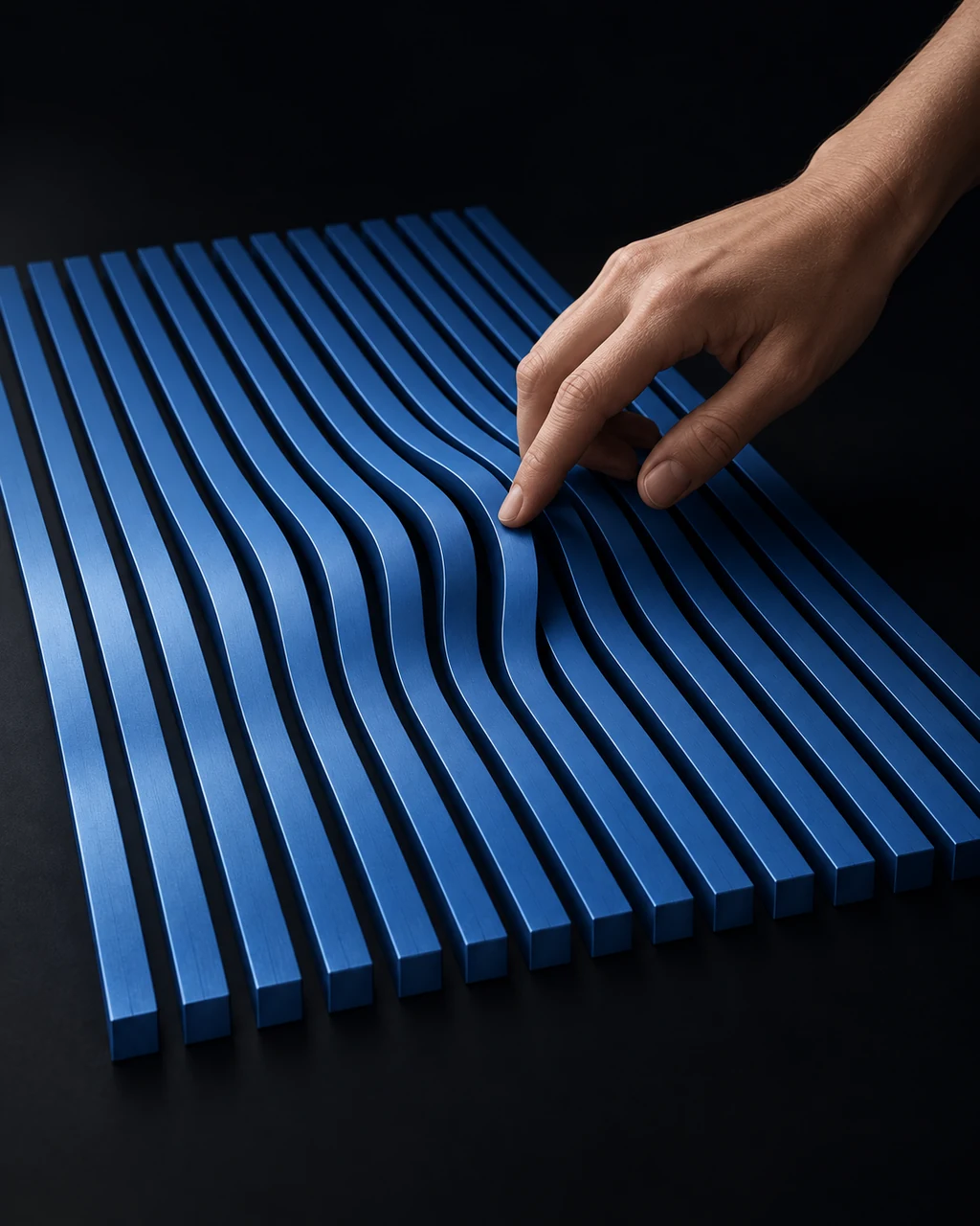 A hand gently shifts a blue band, shaping a precise field of neighbouring bands into a coordinated curve against a dark background.